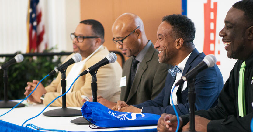 A spread of speakers smiling at their audience.